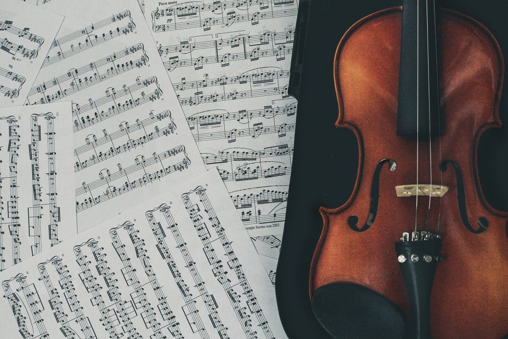 Eine hochwertige Violine liegt im Koffer daneben einige Notenblätter.