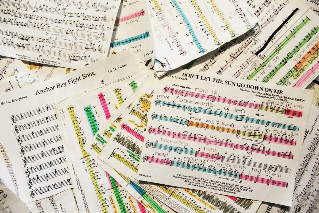 Viele Notenblätter mit farblichen Markierungen und Randkritzeleien liegen kreuz und quer übereinander.